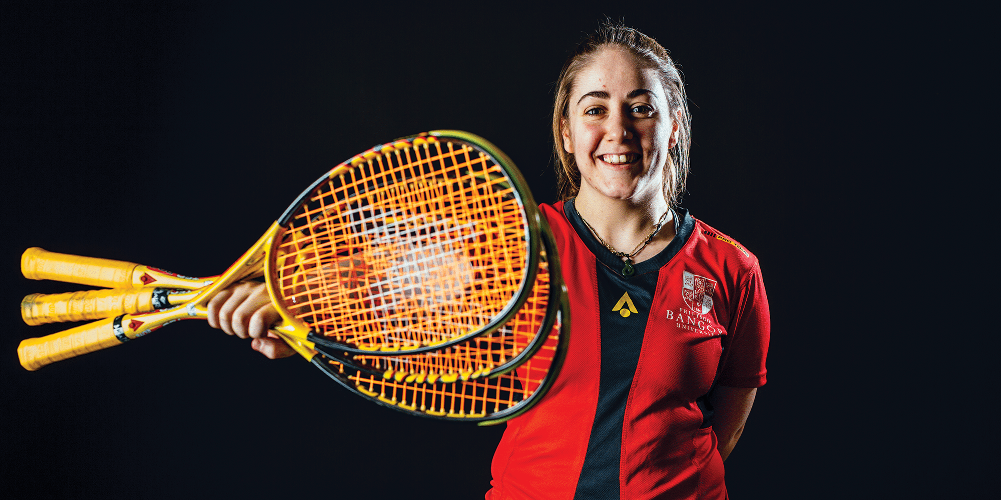 Nainen esittelee kahta squash mailaa