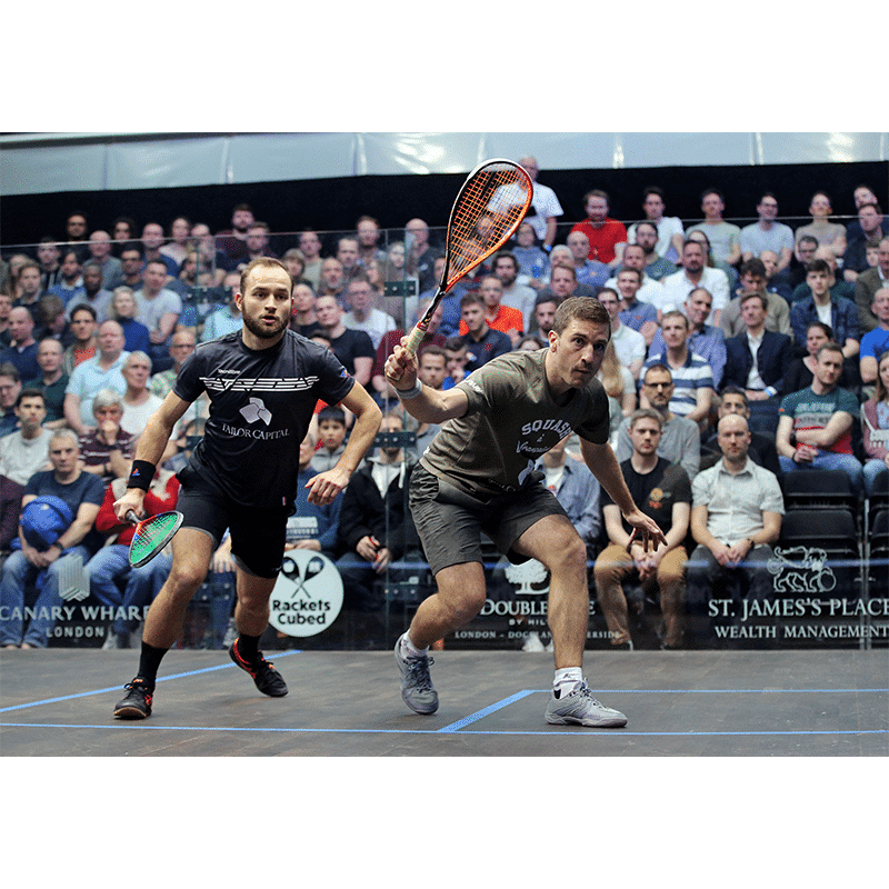 kaksi miestä pelaa squashia